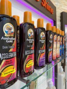 Australian Gold Dark Tanning Accelerator lotion bottles display shelf at The Tanning Shop UK