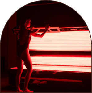 Woman standing next to a red light therapy bed at The Tanning Shop UK – optimal health and skin rejuvenation
