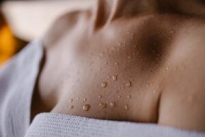Showering after your tanning session - close-up of tanned skin with water droplets after sunbed session at The Tanning Shop UK