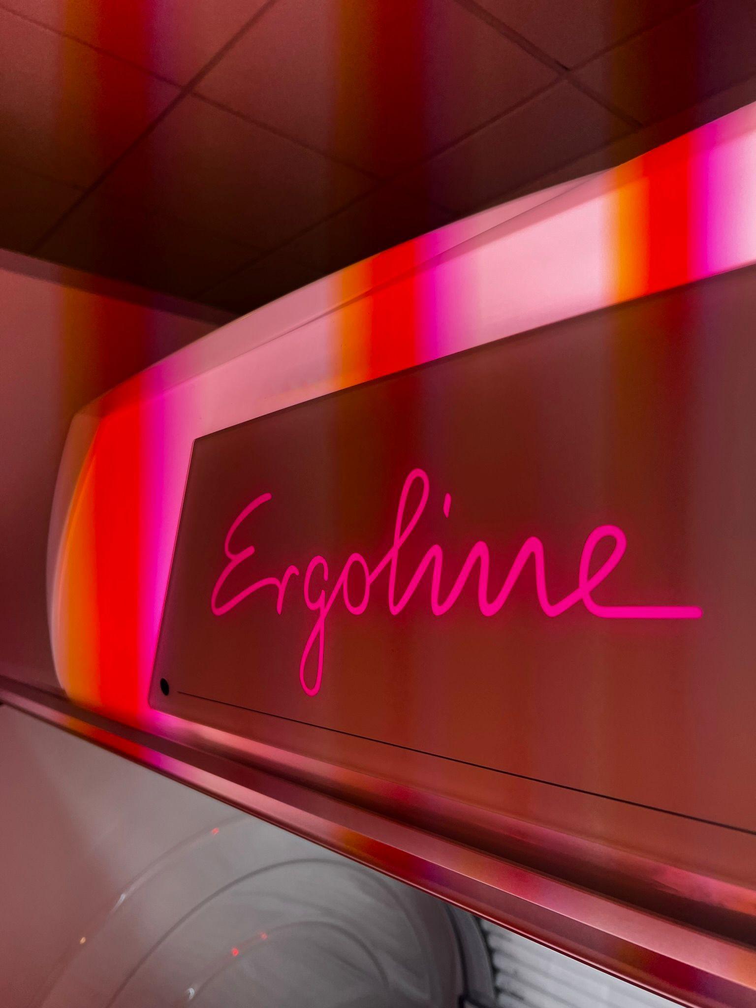 Ergoline premium UV tanning sunbed with glowing pink neon logo inside The Tanning Shop