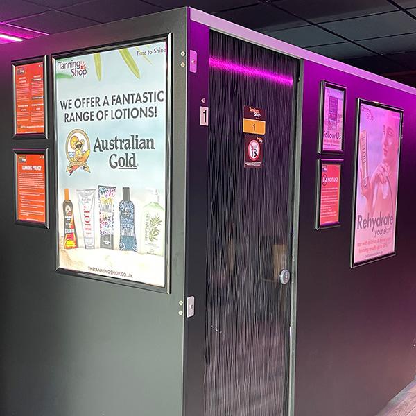 The Tanning Shop Castle Bromwich interior hallway with Australian Gold tanning lotion promotional posters