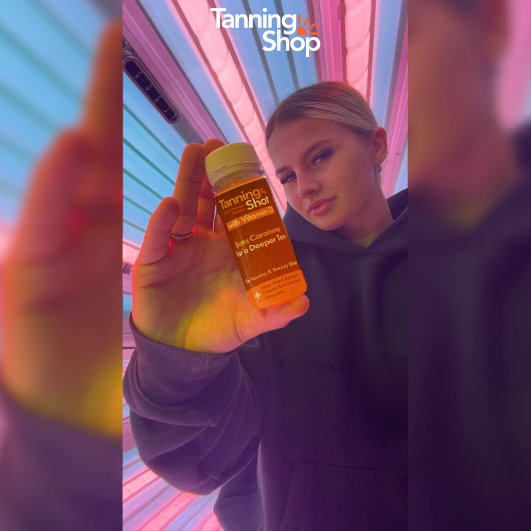 Customer holding Tanning Shot product inside tanning bed at The Tanning Shop Cheltenham
