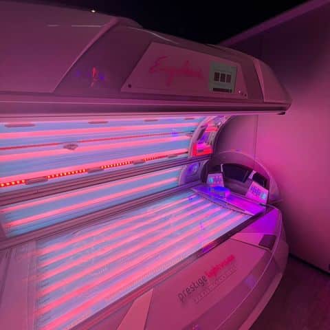 Ergoline Prestige tanning bed with purple and red LED collagen lighting at The Tanning Shop UK