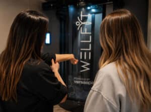 Tanning Shop consultant giving a free personalised WellFit skincare consultation to a customer in salon.