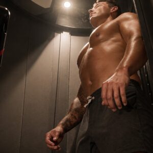 Man inside a spray booth receiving a WellFit and spray tanning treatment at The Tanning Shop. Man inside a spray booth receiving a WellFit and spray tanning treatment at The Tanning Shop.